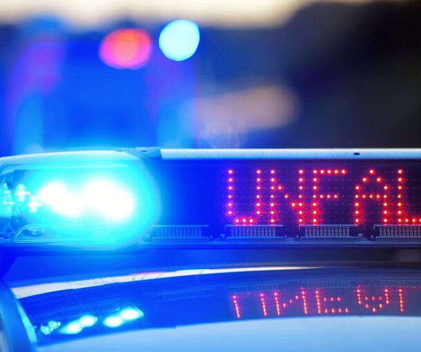Eine Leuchtschrift am Polizeifahrzeug warnt vor der Unfallstelle.