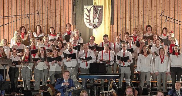 Über hundert Sänger und Musiker stehen auf der Bühne.