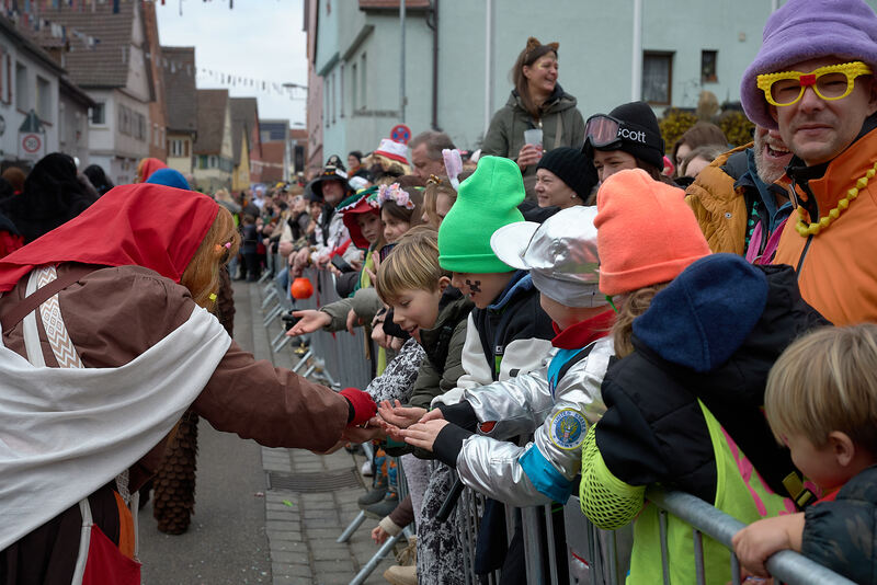 Die Kinder freuen sich über Süßigkeiten.