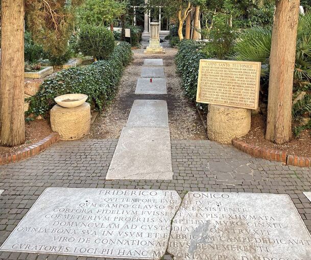 Am Eingang des „Deutschen Friedhofs“ im Vatikan erinnert eine Steinplatte an die Geschichte der Anlage und der Erzbruderschaft, der auch ein in Asperg geborener Verlagsbuchhändler angehörte.