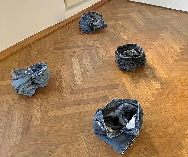 Vier Jeanshosen hat Anna-Lena Joos an Ort und Stelle ausgezogen und als skulpturale Form auf dem Boden hinterlassen – ihre Installation „Hosen runter“ besticht als gewitztes Konzeptkunst-Update und ironischer Kommentar zur Minimal Art in einem.