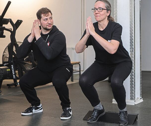 Fitnesstrainer Justin zeigt Redakteurin Julia Schweizer verschiedene Übungen aus dem Bereich „Functional Fitness“: hier die Kniebeuge.