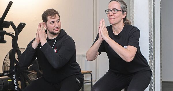 Fitnesstrainer Justin zeigt Redakteurin Julia Schweizer verschiedene Übungen aus dem Bereich „Functional Fitness“: hier die Kniebeuge.