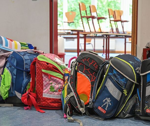 Schulranzen stehen vor einem Klassenzimmer.