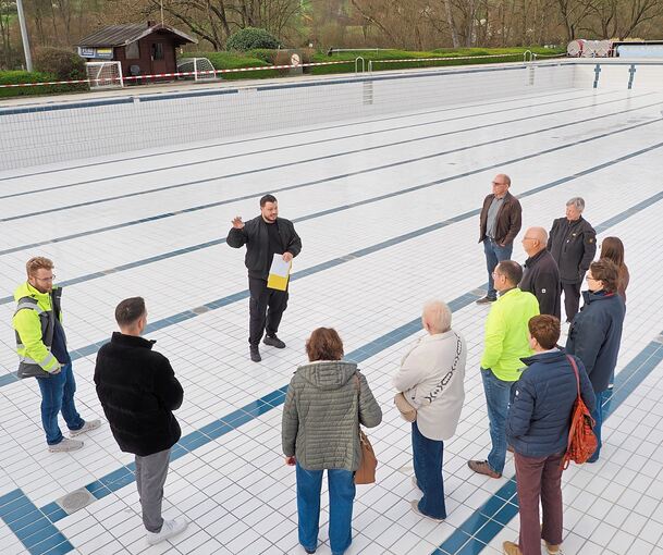 Hier wird im Sommer geschwommen: Die Teilnehmer der Führung stehen im großen Freibadbecken.