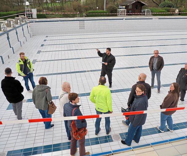 Badleiter Marsel Sakollari erklärt den Teilnehmern im großen Becken des Freibads die Technik.