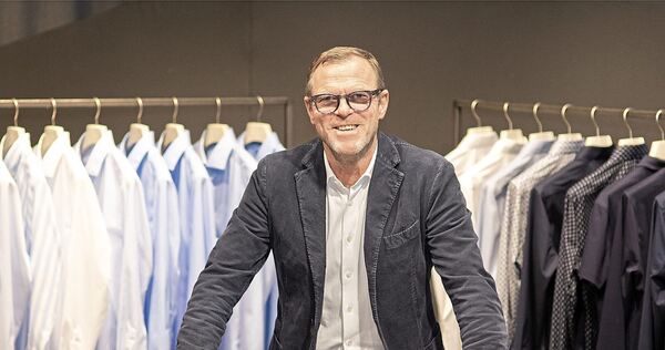 Olymp-Chef Mark Bezner vor Hemden seines Unternehmens.