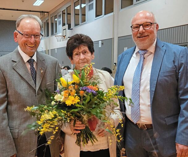 Bürgermeister Rainer Schäuffele (rechts) überreicht Blumen an Rolf Karle und seine Frau.