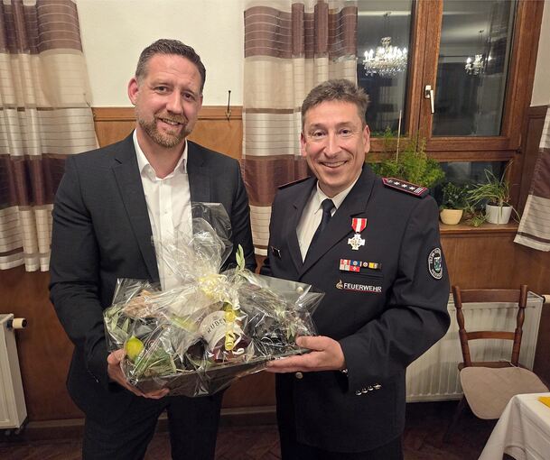 Bürgermeister Günther Pilz (links) überreicht Klaus Haug einen Geschenkkorb.