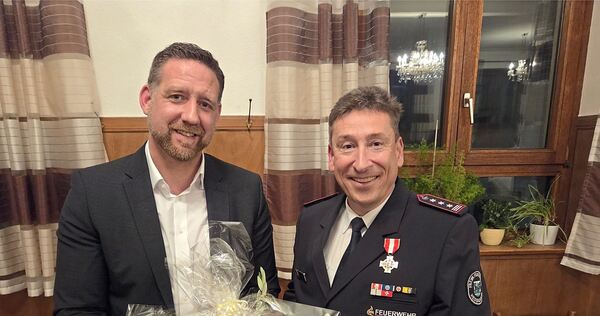 Bürgermeister Günther Pilz (links) überreicht Klaus Haug einen Geschenkkorb.