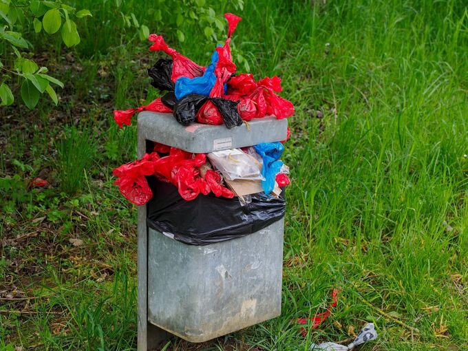 Ein Unbekannter entsorgt seinen Hausmüll in solchen roten Hundetüten in Oßweil.