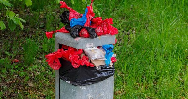 Ein Unbekannter entsorgt seinen Hausmüll in solchen roten Hundetüten in Oßweil.