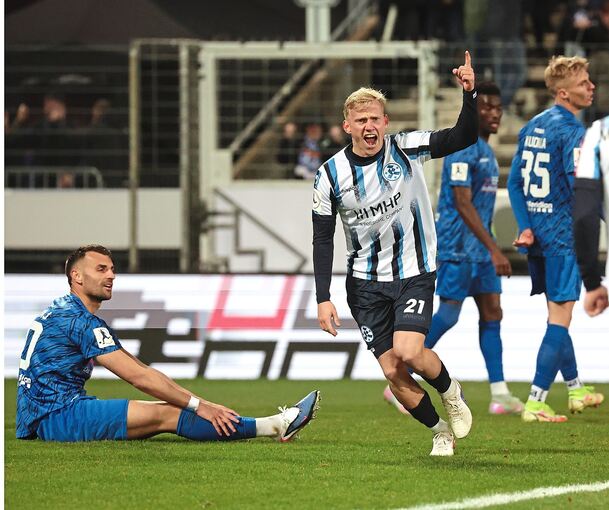 Kickers-Profi Per Lockl bejubelt sein Tor zum 2:1, während Freibergs Innenverteidiger Mehdi Hetemaj frustriert auf dem Rasen sitzt.