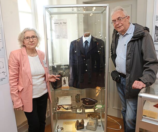 Ingeborg Plachetta und Ulrich Volkmer vor einer Vitrine, die die Uniform eines Schaffners der Strohgäubahn zeigt.