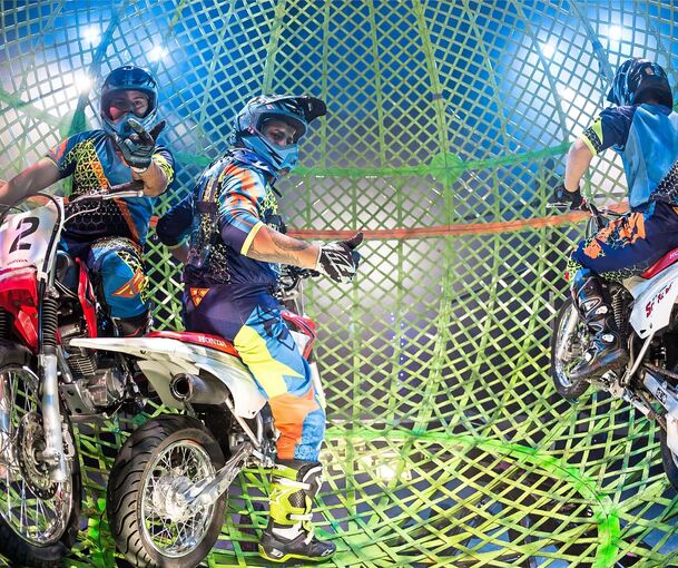 Das Team Nogueira fährt mit Motorrädern in einer Kugel unter dem Zirkusdach.