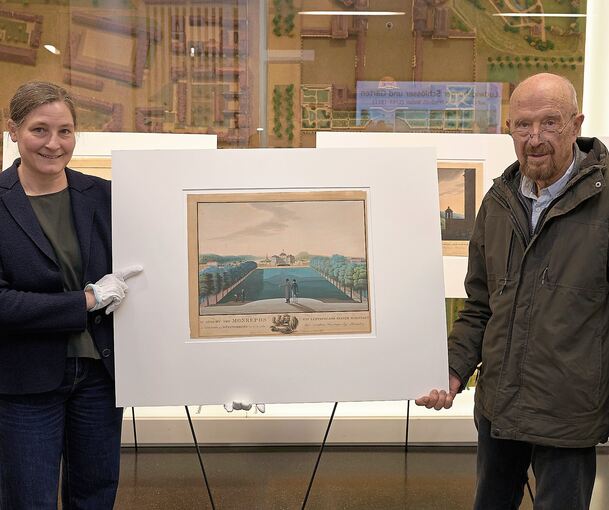 Margrit Röder nimmt die Grafik aus der Sammlung von Günter Leidner entgegen.