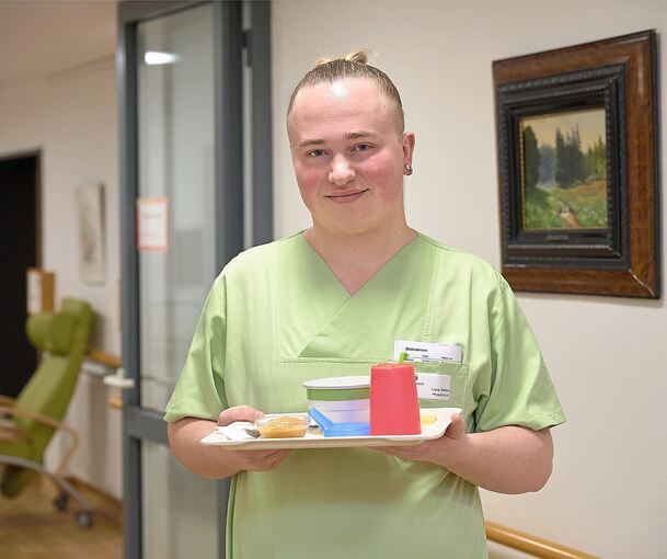Pflege-Azubi Luca Schöck ist mit einem Frühstückstablett auf dem Gang des Möglinger Kleeblatt-Heims unterwegs.