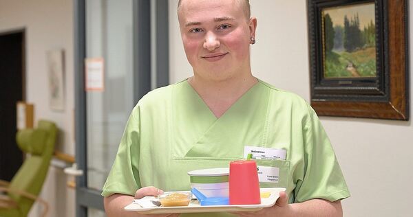 Pflege-Azubi Luca Schöck ist mit einem Frühstückstablett auf dem Gang des Möglinger Kleeblatt-Heims unterwegs.