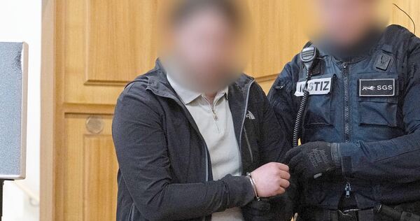 Der Angeklagte G. wird mit Handschließen in den Gerichtssaal geführt.