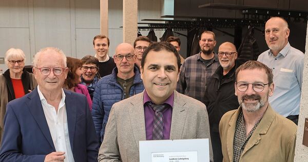 Großbottwars Bürgermeister Ralf Zimmermann mit der Urkunde, die die Harzberghalle als beispielhaften Bau lobt.