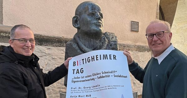 Pfarrer Bernhard Ritter (li.) und Thomas Reusch-Frey mit dem Veranstaltungsplakat vor der Stadtkirche.