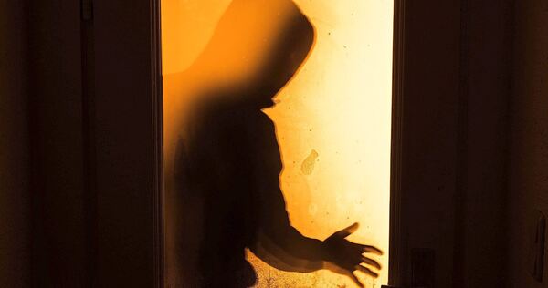 Die Einbrecher hebeln die Eingangstür auf.