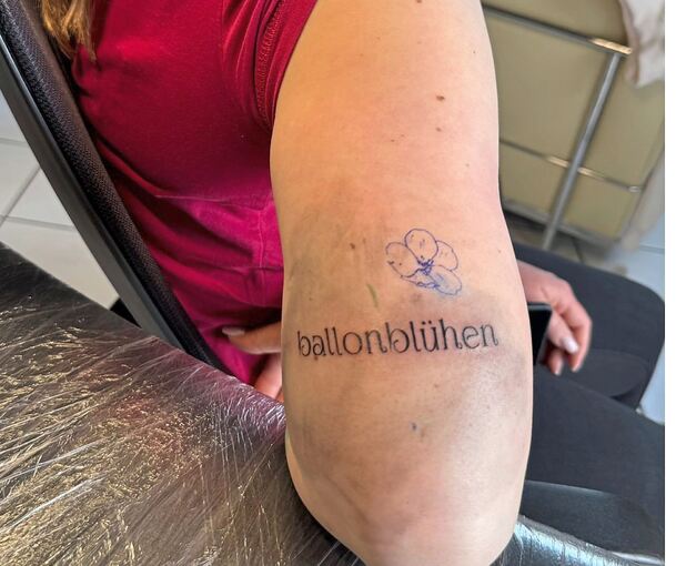 Begeisterung, die unter die Haut geht: Die Modellballonpilotin Jacky Koch lässt sich den Schriftzug und die Blume vom „Ballonblühen“ in den Oberarm tätowieren.
