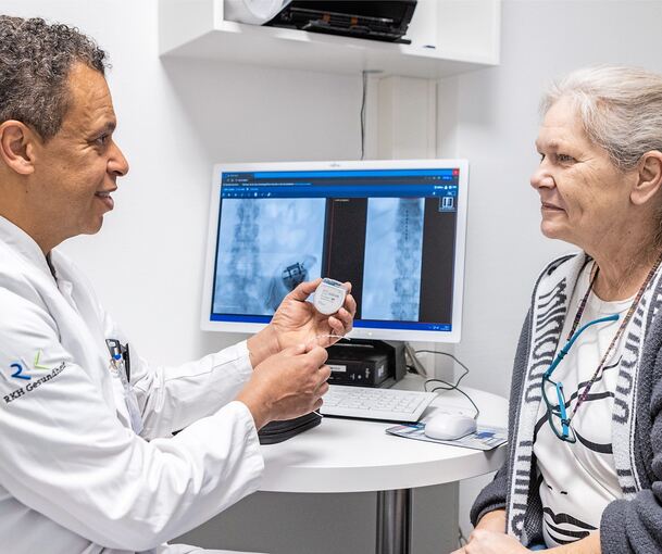 Oberarzt Dr. Chaled Hussein erklärt Patientin Cornelia Ruff die Funktionsweise des „Schrittmachers für die Beine“.