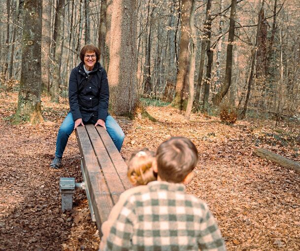 Auf einem Spielplatz im Wald haben Beate Volmari und ihre Enkel Spaß.
