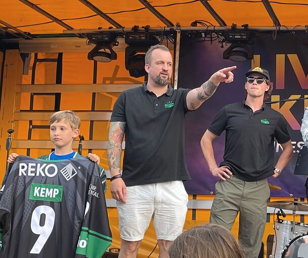 Das Trikot des kanadischen Steelers-Stürmers Brett Kemp (rechts) bringt bei der Versteigerung 750 Euro. Hallensprecher Michael „Fury“ Gärtner betätigt sich als Auktionator.