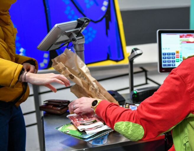 Eine Kassiererin und eine Kundin an einer Kasse