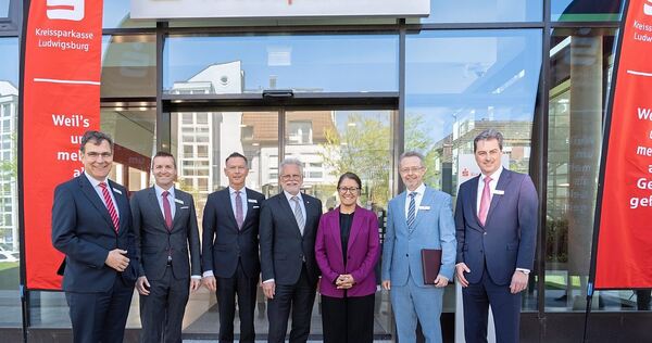 Oberbürgermeister Makurath (Mitte) zwischen zufriedenen Kreissparkassen-Mitarbeitern.