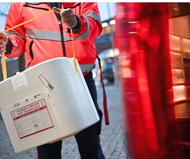 Ein Mitarbeiter der Malteser mit einer Kühlbox für ein Spenderorgan (gestellte Szene).