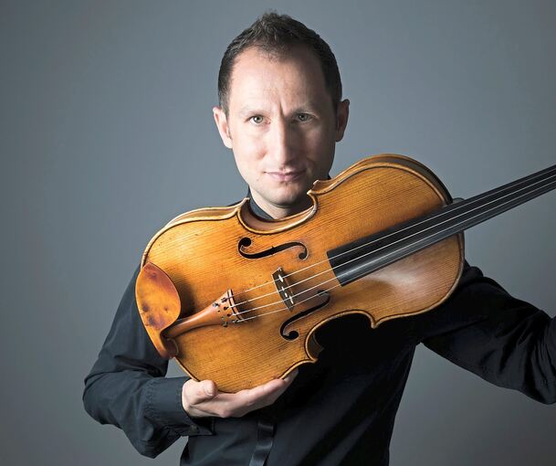 Der Ausnahmebratschist Antoine Tamestit steht mit Mitgliedern des SWR Symphonieorchesters auf der Bühne.