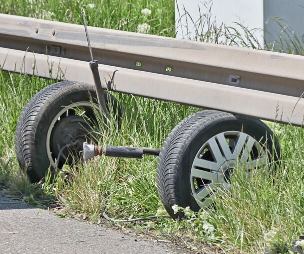 Die verlorene Hinterachse verklemmte sich unter einer Leitplanke.