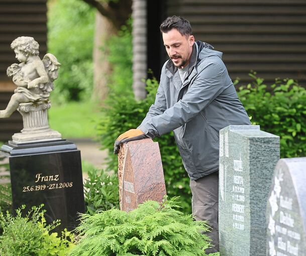 Steinmetz Christian Haller rüttelt an den Grabsteinen auf dem Eglosheimer Friedhof.