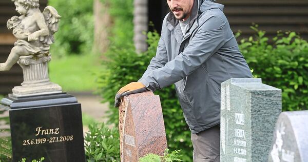 Steinmetz Christian Haller rüttelt an den Grabsteinen auf dem Eglosheimer Friedhof.