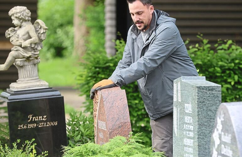 Steinmetz Christian Haller rüttelt an den Grabsteinen auf dem Eglosheimer Friedhof.