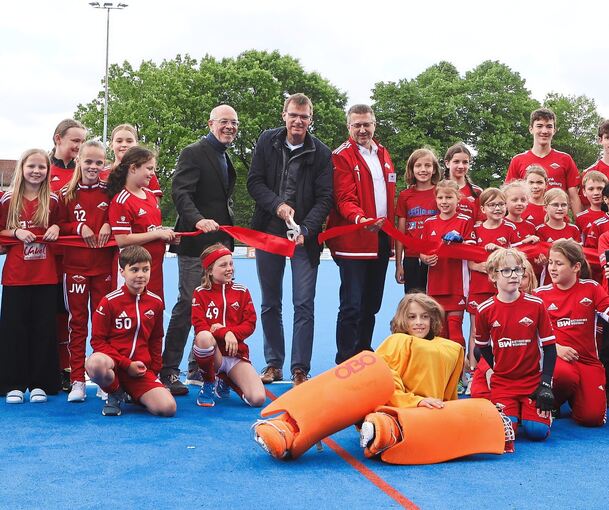 Baubürgermeister Michael Wolf, Sven Heuschele und Götz Andraschko weihten den neuen Kunstrasenplatz des Bietigheimer HTC mit jungen Spielerinnen und Spielern ein.