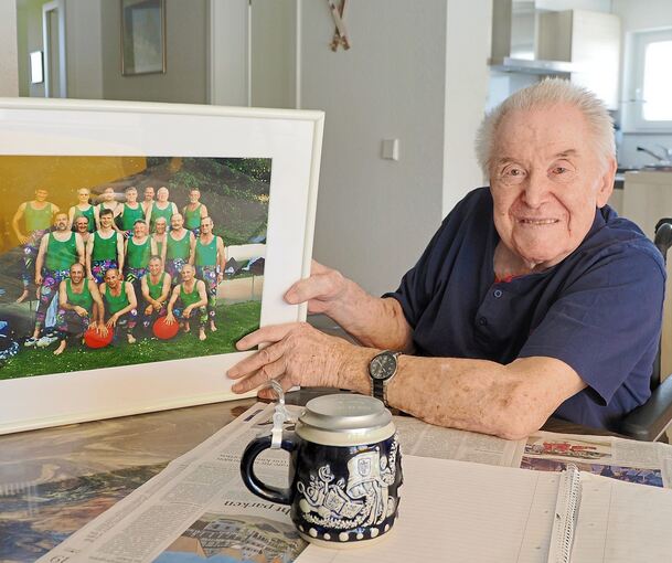Gruppenbild mit Turnern und einem der vielen Krügele: Horst Weng zeigt ein Foto, auf dem er mit seinen Sportskollegen zu sehen ist. Er ist der Vierte von links in der mittleren Reihe.