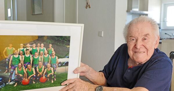 Gruppenbild mit Turnern und einem der vielen Krügele: Horst Weng zeigt ein Foto, auf dem er mit seinen Sportskollegen zu sehen ist. Er ist der Vierte von links in der mittleren Reihe.