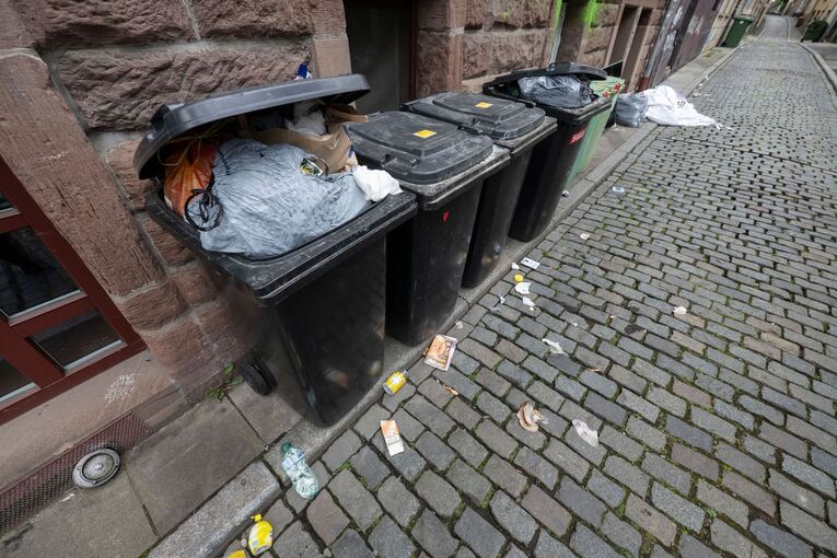 Überquellende Mülltonnen und Abfall in Gasse Überquellende Mülltonnen und Abfall in Gasse