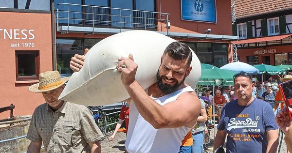 Kräftemessen mit dem Sack auf der Schulter: 100 Kilogramm sollen so weit wie möglich geschleppt werden. Doch auch dieser starke Kräftemessen mit dem Sack auf der Schulter: 100 Kilogramm sollen so weit wie möglich geschleppt werden. Doch auch dieser starke Kandidat schafft es nicht, den Rekord des Müllermeisters Fessler zu knacken.