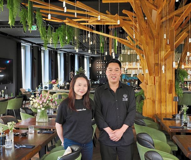 Restaurantleiterin Tra Nguyen und Küchenchef Lam Le stehen im Bietigheimer Restaurant Tutam vor dem großen Wunschbaum für Gäste.