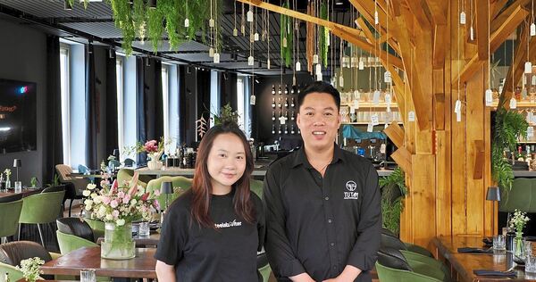 Restaurantleiterin Tra Nguyen und Küchenchef Lam Le stehen im Bietigheimer Restaurant Tutam vor dem großen Wunschbaum für Gäste.