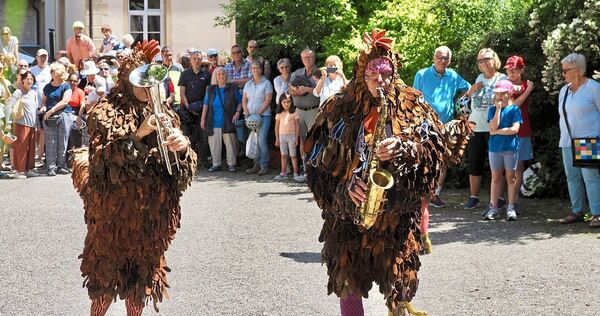 Die Straßenkünstlergruppe PasParTouT in ihren prachtvoll gefiederten Kostümen.