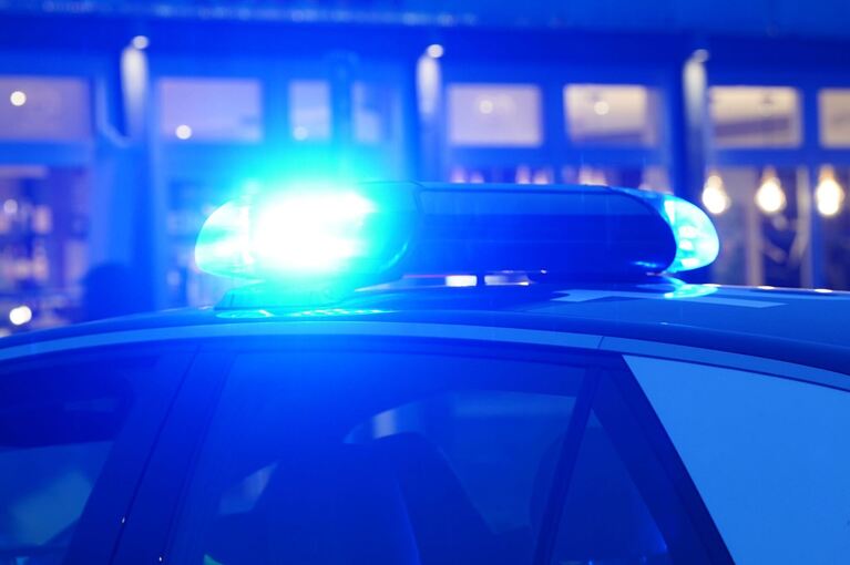Ein Streifenwagen der Polizei mit eingeschaltetem Blaulicht Ein Streifenwagen der Polizei mit eingeschaltetem Blaulicht