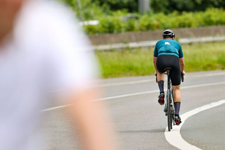 Ein Radfahrer fährt in der Sonne auf seinem Rennrad Ein Radfahrer fährt in der Sonne auf seinem Rennrad