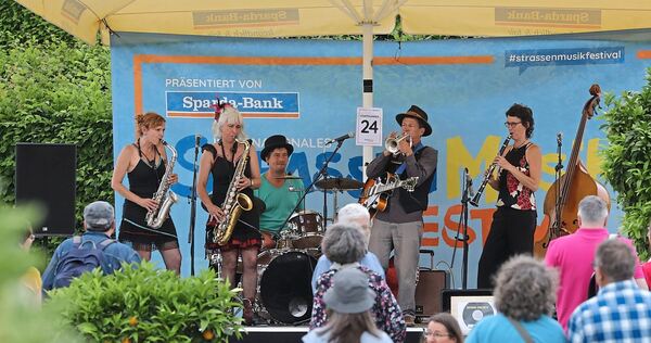 Unter Sonnenschirmen finden Musiker und Besucher Schatten.