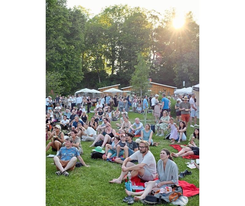 Die Besucher sitzen auf Picknickdecken. Die Besucher sitzen auf Picknickdecken.